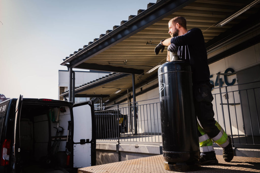 Person står med stor gasolflaska
