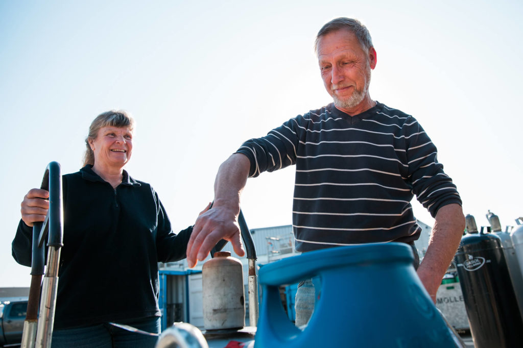 Man och kvinna fyller gasolflaska